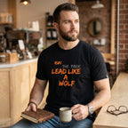 WOFF black cotton unisex t-shirt featuring Run The Pack Lead Like A Wolf graphic print worn by a man in a cafe
