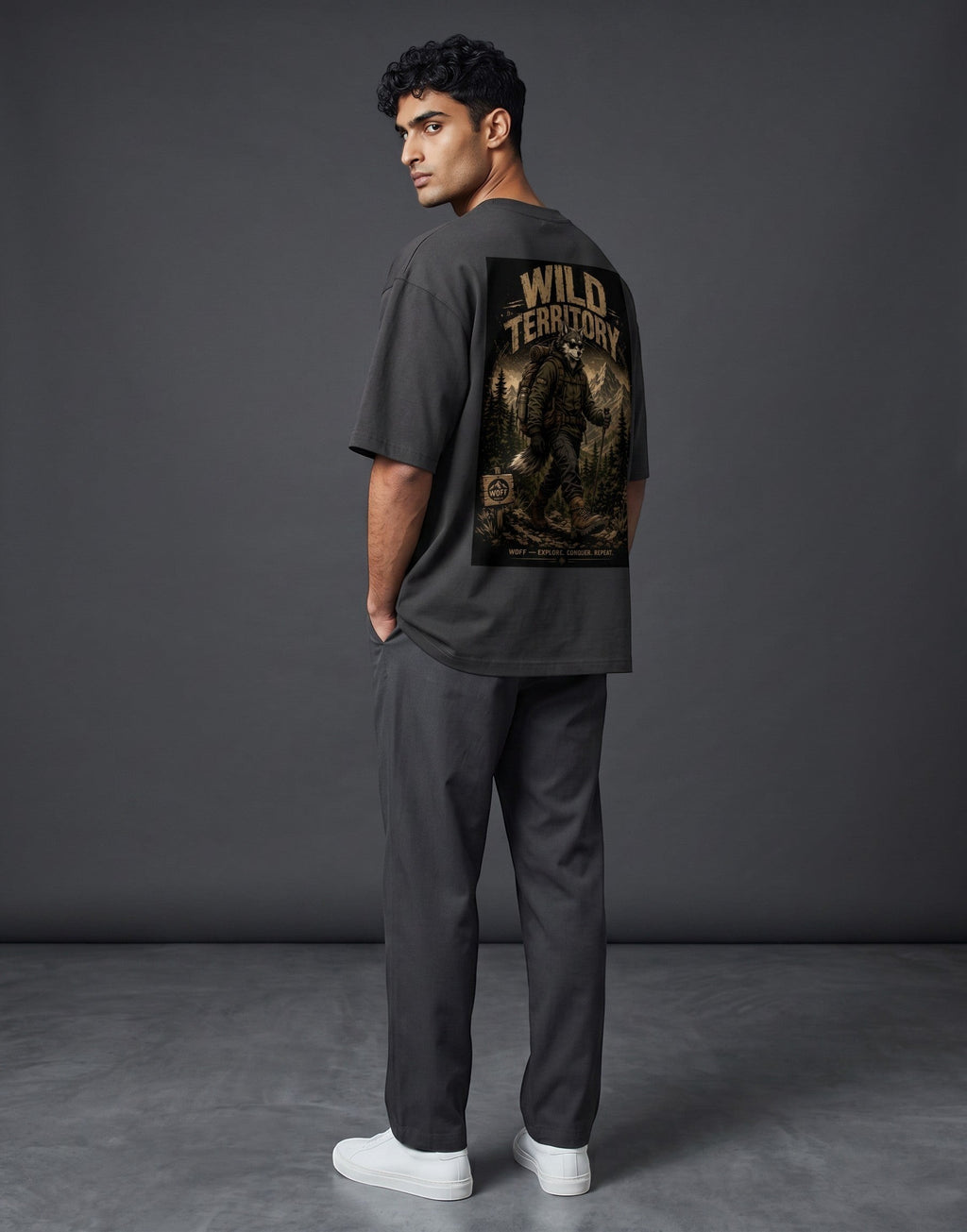 WOFF unisex oversized charcoal cotton t-shirt with Wild Territory graphic print on back, worn by a male model.