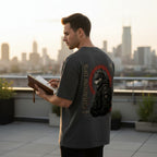 WOFF charcoal grey oversized cotton t-shirt with a wolf graphic print on the back, worn by a man on a city rooftop.