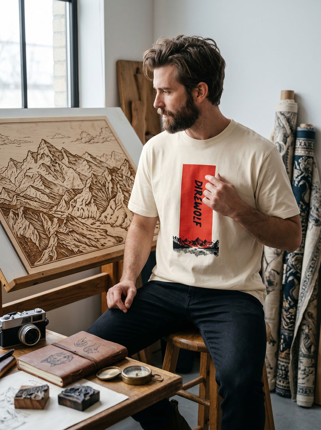 Bearded man wearing a WOFF cream-colored cotton crew neck t-shirt with a red Dire Wolf graphic print.
