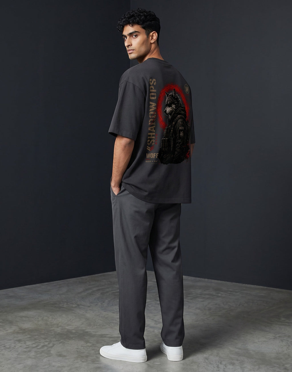 WOFF unisex oversized charcoal cotton t-shirt with Shadow Ops wolf graphic on back, worn by a man in grey trousers.