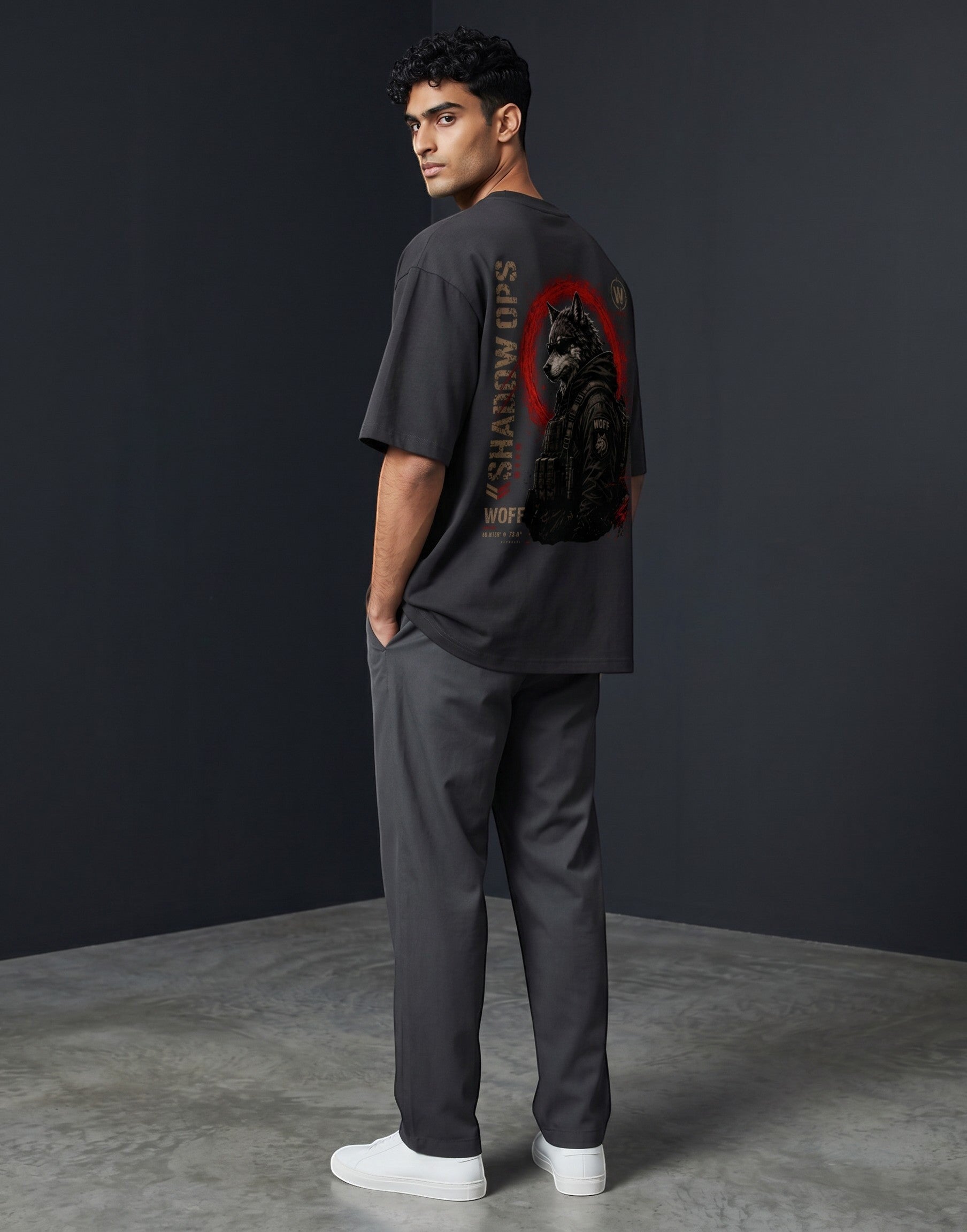WOFF unisex oversized charcoal cotton t-shirt with Shadow Ops wolf graphic on back, worn by a man in grey trousers.