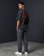 WOFF unisex oversized charcoal cotton t-shirt with Shadow Ops wolf graphic on back, worn by a man in grey trousers.