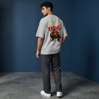 WOFF unisex oversized grey cotton t-shirt with Stay Feral wolf graphic on the back, worn by a man in a studio.