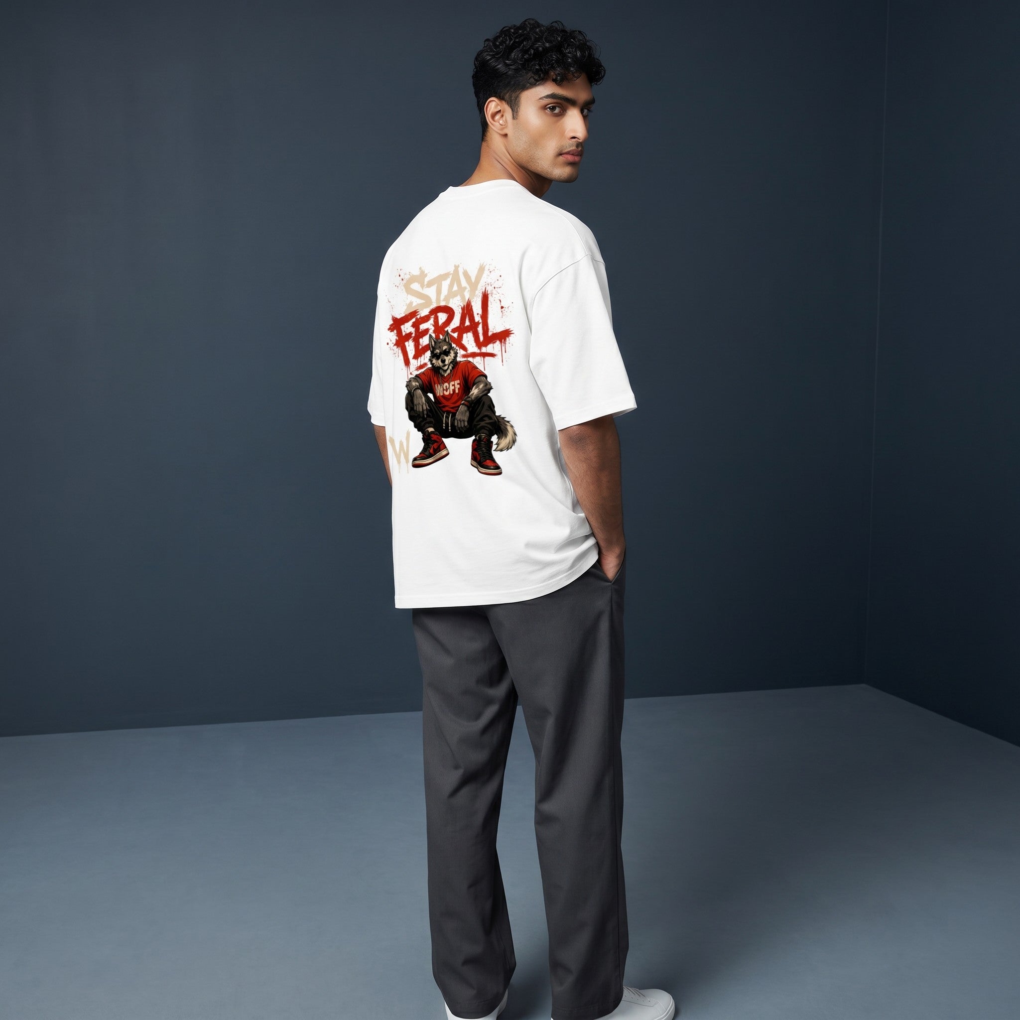 WOFF unisex oversized white cotton t-shirt with Stay Feral graphic print on back worn by a man