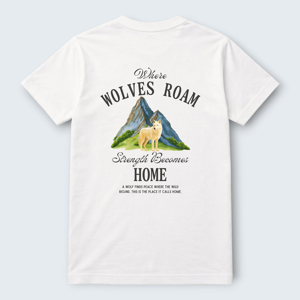 White 100% cotton crew neck t-shirt from WOFF featuring a graphic print of a wolf standing in front of mountains with the text "Where Wolves Roam" and "Strength Becomes Home".