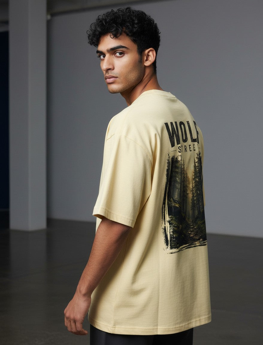 WOFF Wolf Street oversized cotton t-shirt in pale yellow with a forest graphic print on the back worn by a man